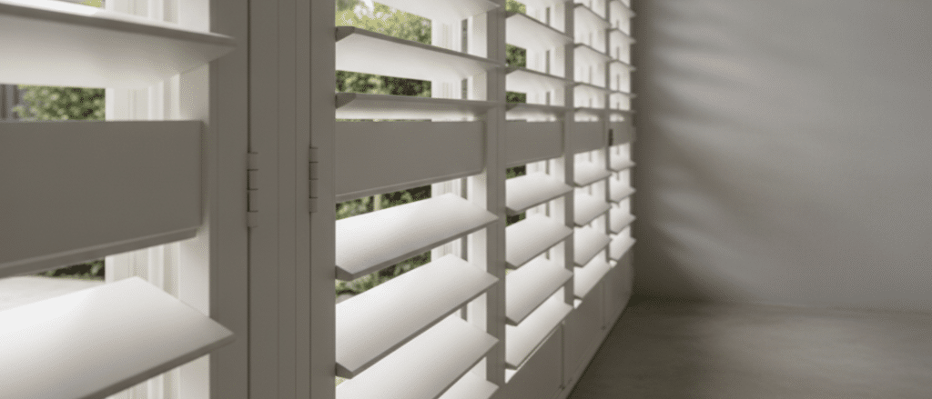 Neutral powder-coated aluminium shutters in a covered patio area, close detail of louvres and frame, clean